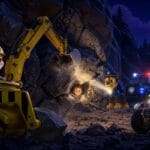 "Rubble y Chase de la Patrulla Canina rescatando al niño Alex atrapado en una cueva oscura tras un desprendimiento de rocas en el bosque."