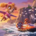 Skye volando y Zuma en su aerodeslizador rescatando cartas de Navidad que caen al mar en los acantilados de Bahía Aventura.